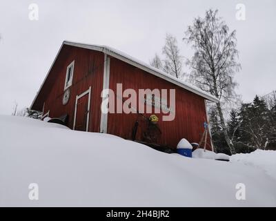 Chalets en bois rouge dans une forêt.Météo enneigée. Banque D'Images