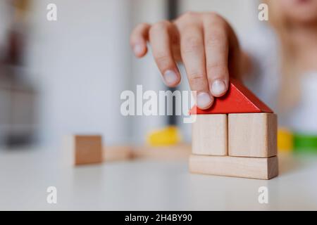 Enfant fille jouant avec des blocs de construction de jouets en bois colorés.Petite tour de bâtiment pour enfants ou maison à la maison ou à la garderie.Jouets éducatifs pour jeunes enfants Banque D'Images