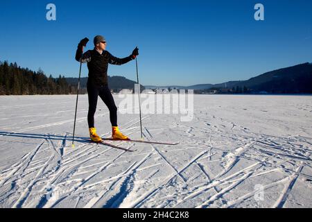 Les skieurs de fond profitent du soleil sur le Titisee gelé dans le Schwarzwald Banque D'Images