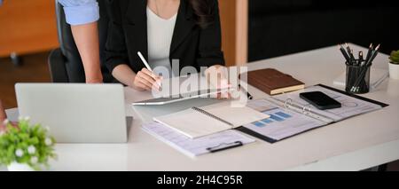 Photo rognée d'un patron masculin et d'une directrice générale féminine qui consulte la stratégie d'entreprise sur leur lieu de travail. Banque D'Images