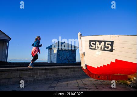 Brighton UK 2 novembre 2021 - un coureur matinal le long du front de mer de Brighton par une journée froide et fraîche alors que le temps va devenir beaucoup plus frais au cours des prochains jours : Credit Simon Dack / Alay Live News Banque D'Images