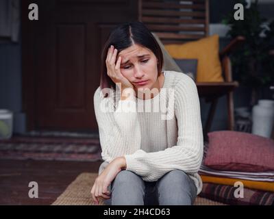 Jeune femme asiatique déprimée assise sur le porche de l'arrière-cour.Elle se sent triste et inquiète de souffrir de dépression en santé mentale.Santé mentale, anxiété dépressive pensant chinoise dame. Banque D'Images