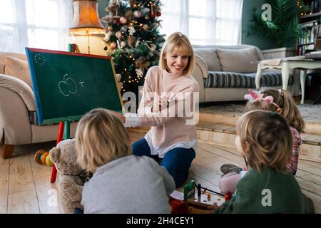 Éducation, concept de maternelle. Groupe d'enfants d'âge préscolaire à l'écoute de l'enseignant. Banque D'Images