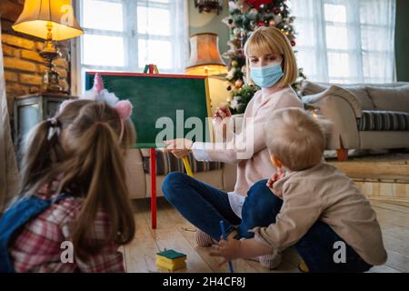 Enfant avec masque et enfants jouant ensemble. Éducation, concept de coronavirus Banque D'Images