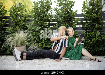 Couple regarder quelque chose sur la tablette numérique dans le jardin Banque D'Images
