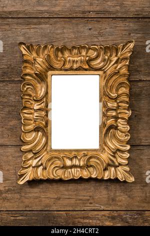Cadre d'image vierge doré et audacieux vertical sur un mur en bois rustique, zone d'image isolée avec un chemin d'écrêtage Banque D'Images