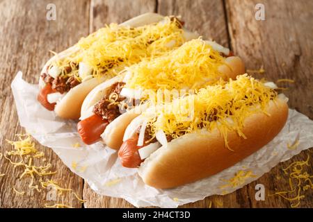 Hot dog au piment américain avec saucisse de bœuf, cheddar et oignons gros plan sur un fond en bois ancien. Horizontal Banque D'Images