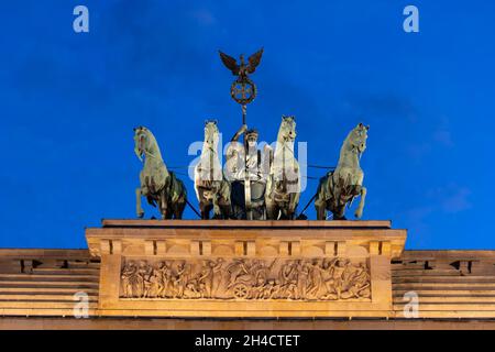 Quadriga de la porte de Brandebourg la nuit dans la ville de Berlin, Allemagne.Statue avec char dessiné par quatre chevaux par Victoria, déesse romaine de la victoire. Banque D'Images