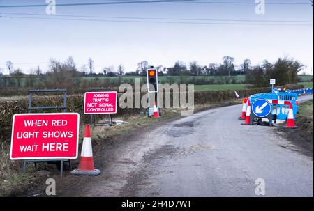 Feu de circulation sur rouge à la route fonctionne sur une route rurale, Country Lane, Buckinghamshire, Royaume-Uni Banque D'Images
