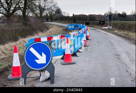 Roadworks avec des cônes de signalisation et un panneau d'avertissement sur une route de campagne rurale à Buckinghamshire, Royaume-Uni Banque D'Images