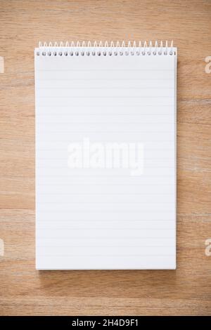 Le bloc-notes White Secretary est ouvert sur un bureau en bois.Arrière-plan ou modèle avec espace de copie sur bloc-notes vide Banque D'Images