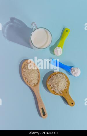 Lait de riz végétalien en poudre. Un verre de lait sur fond multicolore Banque D'Images