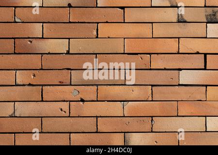 Vieux mur de briques orange avec trous et fissures de fond Banque D'Images