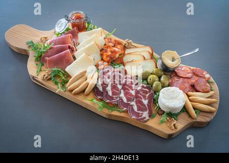 Carte de tapas très colorée de charcuterie avec fromage et viandes fumées.Décoration avec arugula et noix.En-cas au vin. Banque D'Images