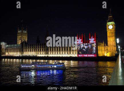 La vidéo de Band Aid 30, « est-ce que c'est Noël ? », est projetée pour la première fois sur les chambres du Parlement.Il marque la copie papier du CD en vente demain matin (08/12/14).la chanson présente des artistes dont One Direction, Ellie Goulding, Emeli SandŽ et Ed Sheeran, entre autres. Banque D'Images