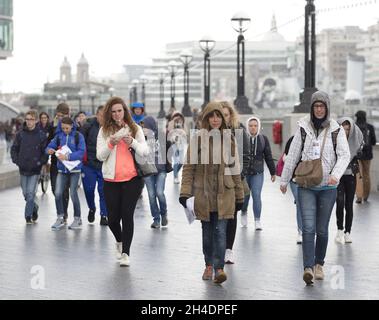 Des gens sont pris dans une tempête de grêle à Southbank près de Tower Bridge, Londres, le mardi 26 avril.Le Royaume-Uni doit faire face à une course à froid record jusqu'en mai avec des températures glaciales et des prévisions de neige pour les 10 prochains jours. Banque D'Images