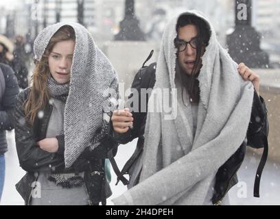 Des gens sont pris dans une tempête de grêle à Southbank près de Tower Bridge, Londres, le mardi 26 avril.Le Royaume-Uni doit faire face à une course à froid record jusqu'en mai avec des températures glaciales et des prévisions de neige pour les 10 prochains jours. Banque D'Images