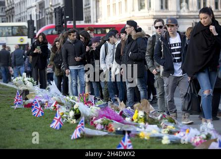 Les gens regardent les hommages floraux laissés sur la place du Parlement en face des chambres du Parlement deux jours après l'attentat terroriste de Londres.Photo datée du vendredi 24 mars 2017.Crédit photo devrait se lire: Isabel Infantes / EMPICS Entertainment. Banque D'Images