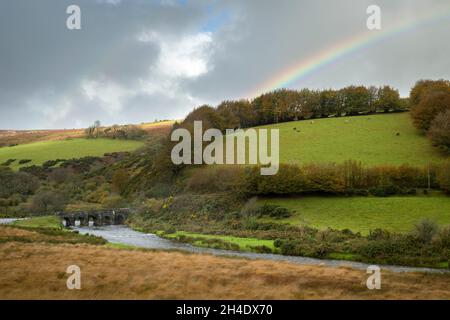 Un arc-en-ciel au-dessus du pont médiéval Landacre qui enjambe la rivière Barle en automne près de Withypool dans le parc national d'Exmoor, Somerset, Angleterre. Banque D'Images