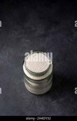 pot de billes de sagou ou de perles de tapioca isolées sur un fond texturé foncé, prises d'en haut avec l'espace de copie Banque D'Images