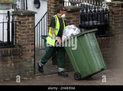 Un collectionneur de déchets Islington council portant un masque facial libère les bacs de recyclage des résidents locaux du nord de Londres.Date de la photo: Jeudi 11 juin 2020. Banque D'Images