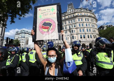 Un démonstrateur de Black Lives Matter tient un écriteau devant des policiers anti-émeutes à Trafalgar Square, Londres.Date de la photo: Samedi 13 juin 2020. Banque D'Images