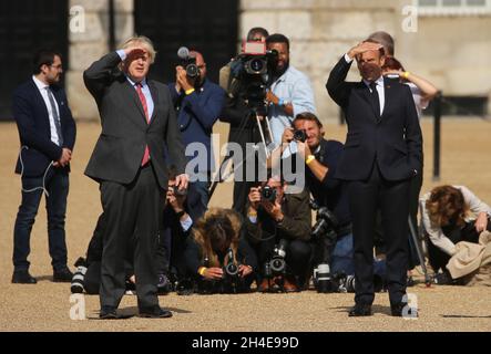 (À gauche) le Premier ministre Boris Johnson et le président français Emmanuel Macron à Horse Guards Parade devant le flipper des flèches rouges et de leur équivalent français, la Patrouille de France, à Londres, pour marquer le 80e anniversaire de la diffusion en temps de guerre du leader français de la résistance Charles de Gauleâ€™s.Date de la photo: Jeudi 18 juin 2020. Banque D'Images