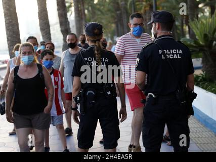 Des policiers locaux patrouillent les personnes portant une couverture faciale à la plage de Poniente à Benidorm, une station balnéaire de la côte est de l'Espagne,Comme l'industrie touristique en Espagne a été durement touchée par la dernière exigence de quarantaine de 14 jours par le gouvernement britannique pour tous les touristes qui voyagent de l'Espagne en raison de ses niveaux élevés de cas COVID-19.Date de la photo : vendredi 31 juillet 2020. Banque D'Images