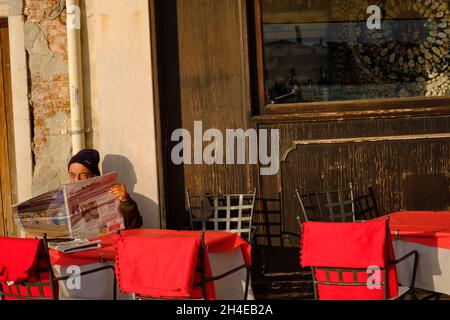 Homme âgé lisant des journaux au bar de Venise en Italie Banque D'Images