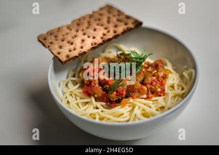 Pâtes avec sauce tomate dans un bol rond avec craquelins Banque D'Images