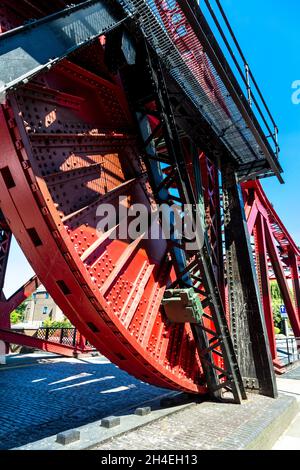 Pont bascule en acier rouge des années 1930 au-dessus du bassin de Shadwell, Wapping, Londres, Royaume-Uni Banque D'Images