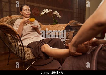 Client recevant un massage thaïlandais relaxant des pieds dans le centre de bien-être Banque D'Images