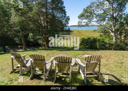 Quatre chaises adirondack en bois donnant sur la mer Banque D'Images