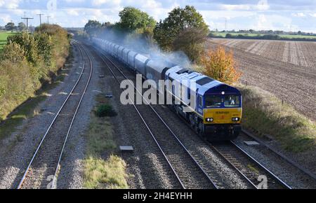 Dans la décoration bleue Beacon Rail Leasing, ancienne locomotive Diesel Electric 66797 de classe européenne 66 avec un train de Washwood Heath - Tunstead à granulats vides Banque D'Images