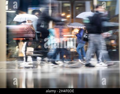 02 novembre 2021, Hessen, Francfort-sur-le-main: Les gens se précipitent dans la zone piétonne de Francfort par temps pluvieux.(Prise de vue avec un temps d'exposition plus long et un effet de glissement) photo: Frank Rumpenhorst/dpa Banque D'Images