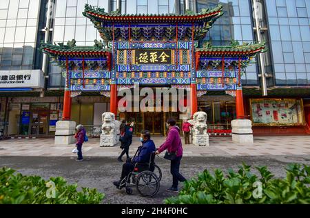 Pékin, Chine.02 novembre 2021.Des personnes qui portaient des masques faciaux marchent devant la porte du restaurant de canard Quanjude de Beijing.en date du 2 novembre 2021, dans la nouvelle série de propagation de l'épidémie de covid-19, 35 cas locaux ont été signalés à Beijing, la capitale de la Chine.Crédit : SOPA Images Limited/Alamy Live News Banque D'Images