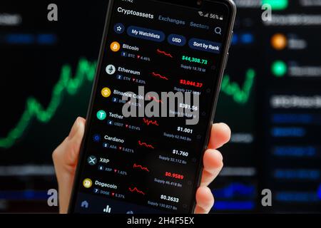 Ukraine, Odessa - octobre 9 2021 : main tenant mobile avec l'application CoinMarketCap fonctionnant sur l'écran de smartphone avec la liste des prix de crypto-monnaie actuels, Banque D'Images