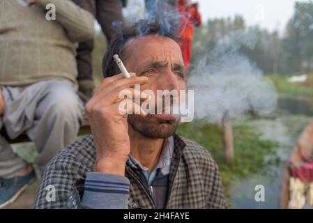 Srinagar, Inde.02 novembre 2021.Un homme cachemiri fume pendant une matinée froide dans les intérieurs de dal Lake.Dal Lake est célèbre pour son marché de légumes flottant, qui fournit des variétés de légumes toute l'année à de nombreuses villes à travers la vallée du Cachemire.Crédit : SOPA Images Limited/Alamy Live News Banque D'Images