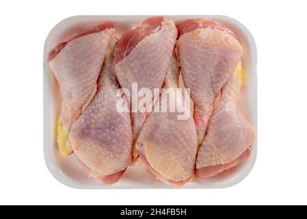 six pattes de poulet dans un plateau alimentaire en plastique isolé sur fond blanc, chemin d'écrêtage, vue du dessus Banque D'Images