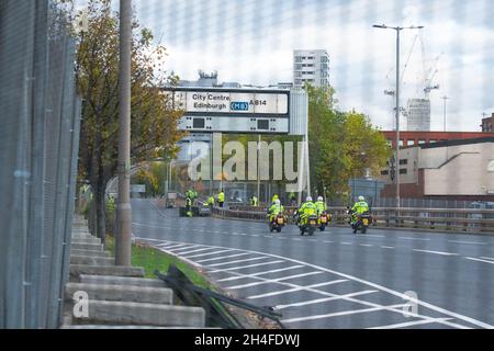 Glasgow, Écosse, Royaume-Uni.2 novembre 2021.Vue à travers des clôtures de sécurité métalliques, la A814 Clydeside Expressway qui longe le campus de la SEC.La route est utilisée pour escorter les dirigeants du monde qui séjournent à l'extérieur de Glasgow vers et depuis le site.Photo: Voitures à l'extérieur des portes de sécurité attendant d'entrer après les contrôles de sécurité et les motos de police crédit: Kay Roxby/Alamy Live News Banque D'Images