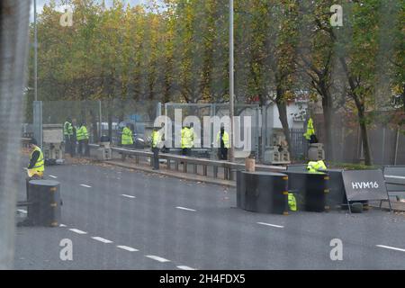 Glasgow, Écosse, Royaume-Uni.2 novembre 2021.Vue à travers des clôtures de sécurité métalliques, la A814 Clydeside Expressway qui longe le campus de la SEC.La route est utilisée pour escorter les dirigeants du monde qui séjournent à l'extérieur de Glasgow vers et depuis le site.Photo: Voitures à l'extérieur des portes de sécurité attendant d'entrer après les contrôles de sécurité crédit: Kay Roxby/Alamy Live News Banque D'Images