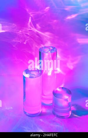 trois podiums en verre transparent sur fond rose pastel Banque D'Images