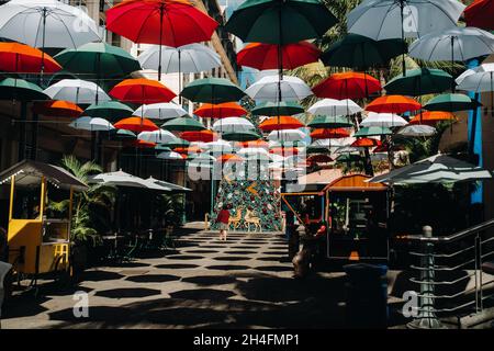 Port Louis, Maurice, couvert de parasols promenade le long de la promenade Leodan dans la capitale. Banque D'Images