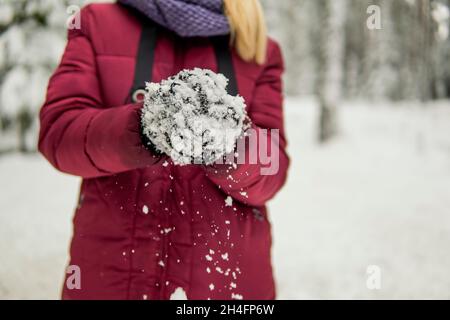 Une fille sculpte le globe de neige dans la forêt d'hiver. De haute qualité Banque D'Images