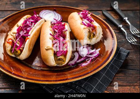 Street food - hot-dogs végétaliens avec du chou et des saucisses sans viande.Arrière-plan en bois sombre.Vue de dessus Banque D'Images