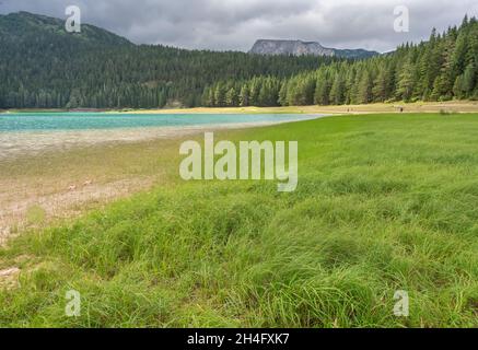 À Black Lake emplacement avec le mont Durmitor dans la distance, avec des conifères et des nuages sombres orageux approchant. Banque D'Images