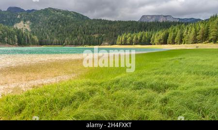 À Black Lake emplacement avec le mont Durmitor dans la distance, avec des conifères et des nuages sombres orageux approchant. Banque D'Images