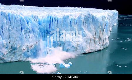 vue par drone d'un morceau de glace de glacier qui se brise et tombe dans l'eau de mer en raison de la fonte de la glace due au changement climatique. Banque D'Images