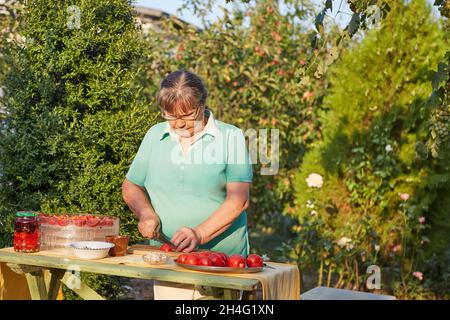 Coupe femme tomates, dans le jardin, en été, au coucher du soleil Banque D'Images