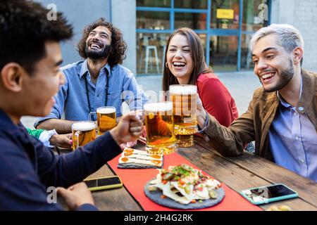 Groupe d'amis hippster prenant un verre sur la terrasse du bar Banque D'Images